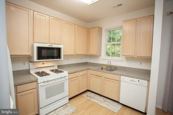 a kitchen with white cabinets and white appliances