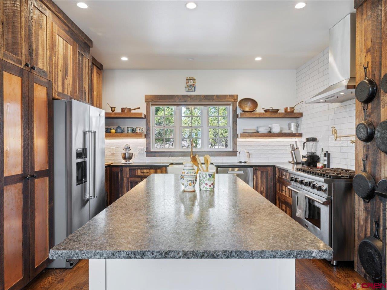 810 Pine Drive Ridgway, CO 81432 - Photo 12 of 36 a kitchen with stainless steel appliances granite countertop a stove a refrigerator a kitchen island a stove and a refrigerator