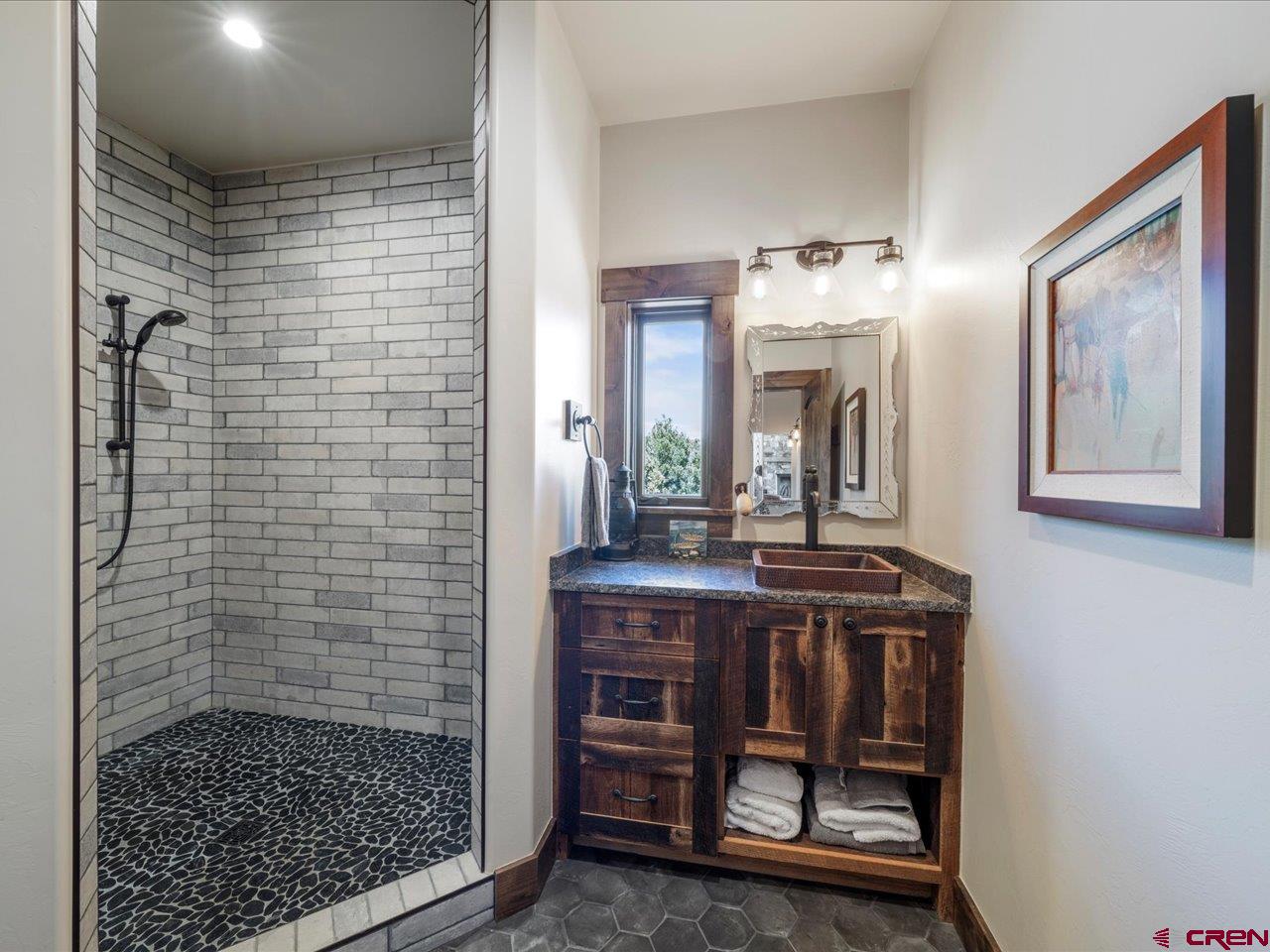 810 Pine Drive Ridgway, CO 81432 - Photo 19 of 36 a bathroom with a sink a mirror and a shower