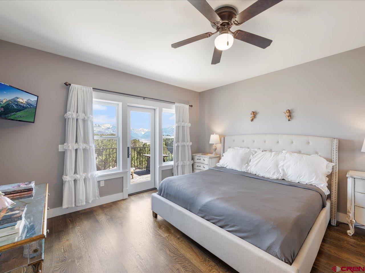 810 Pine Drive Ridgway, CO 81432 - Photo 27 of 36 a bedroom with a large bed and a chandelier fan