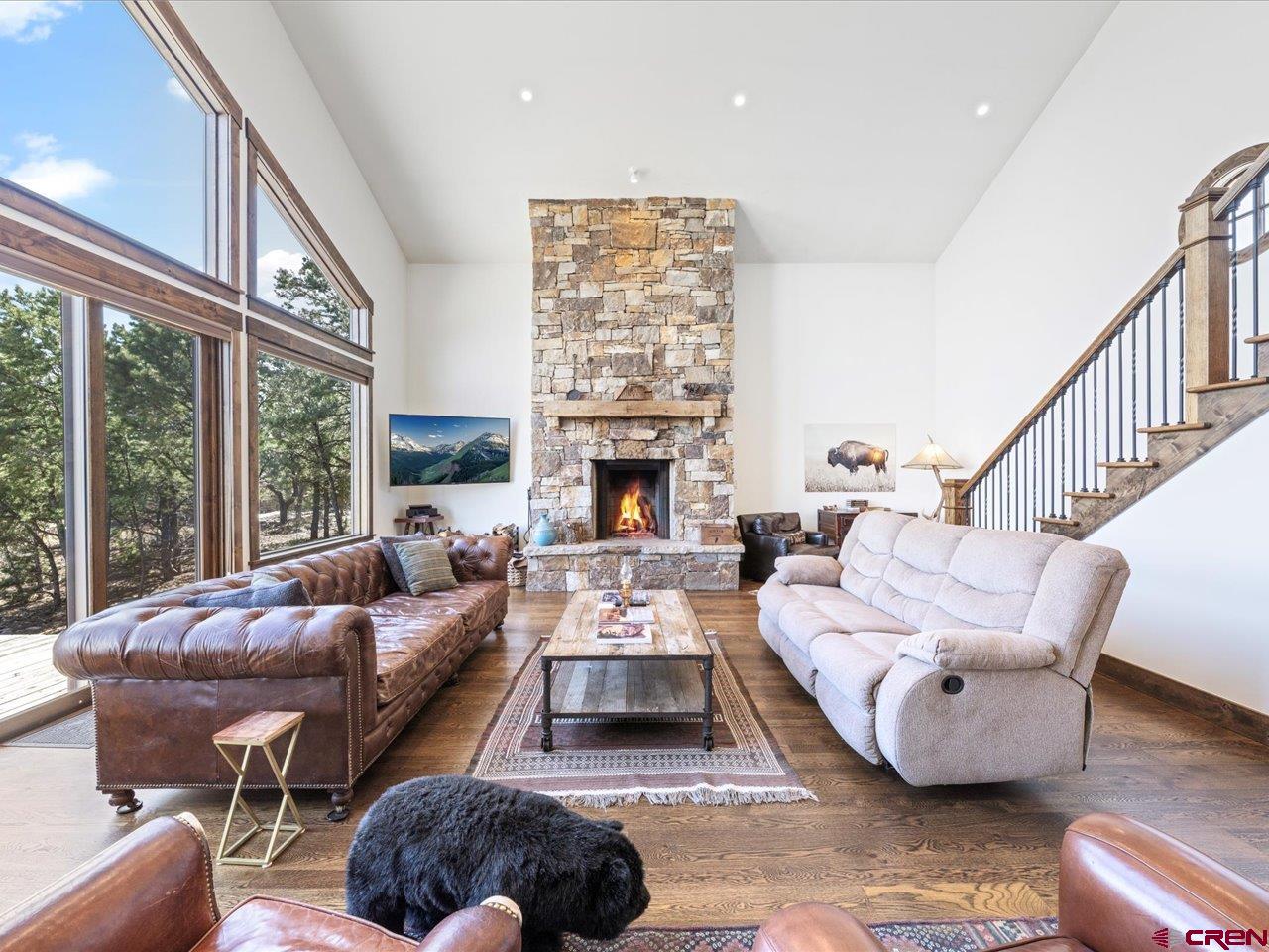 810 Pine Drive Ridgway, CO 81432 - Photo 8 of 36 a living room with furniture a fireplace and large windows