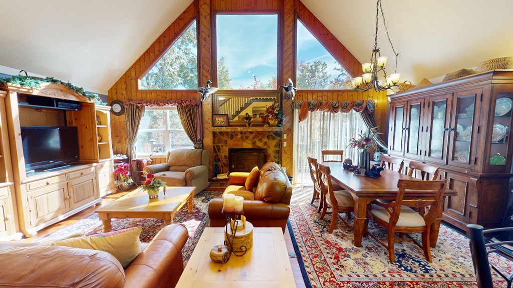 52 Bear Track Road Andrews, NC 28901 - Photo 10 of 38 a living room with furniture a flat screen tv and a floor to ceiling window