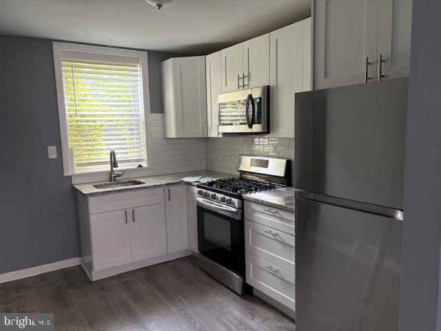 532 Dudley Street Philadelphia, PA 19148 - Photo 5 of 14 a kitchen with granite countertop white cabinets and stainless steel appliances
