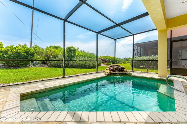 a view of a white house with a big yard and potted plants