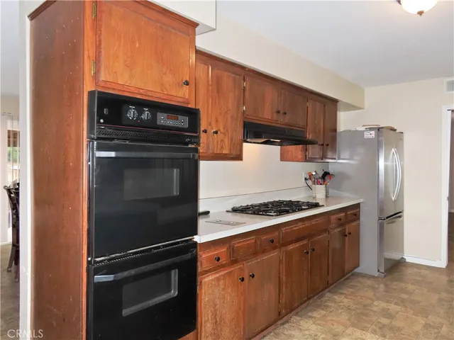 a kitchen with stainless steel appliances a refrigerator a stove a sink and a refrigerator