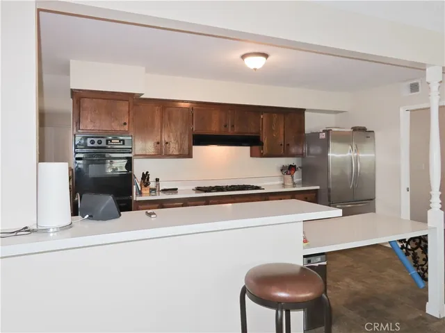 a kitchen with granite countertop a sink a stove and refrigerator