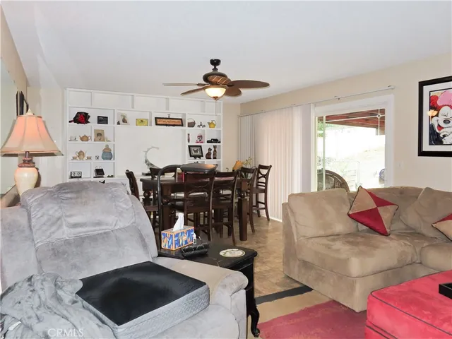 a living room with furniture kitchen view and a window