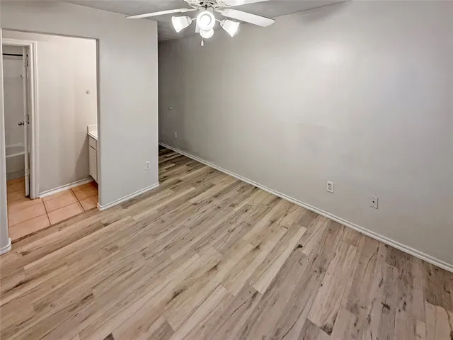 an empty room with wooden floor and door