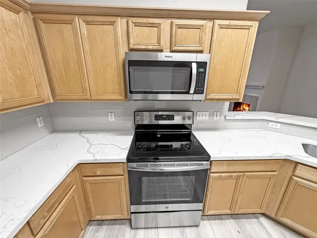 a kitchen with granite countertop white cabinets and black appliances