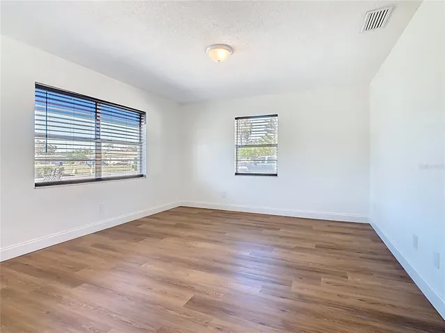 a view of a kitchen with wooden floor and a refrigerator