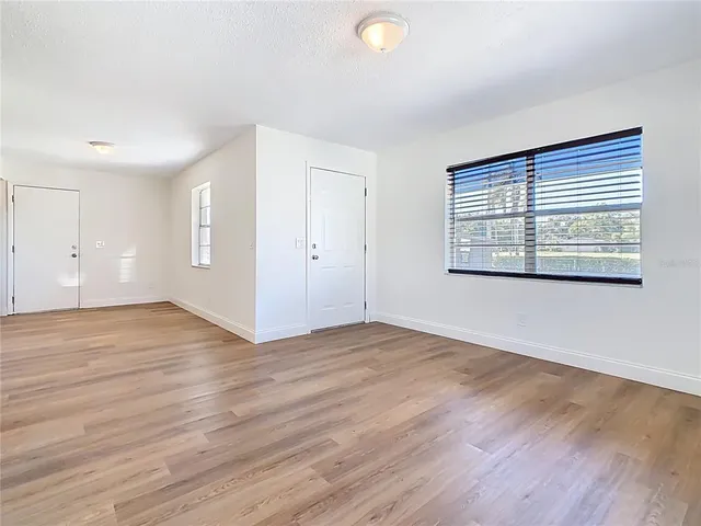 a view of empty room with wooden floor