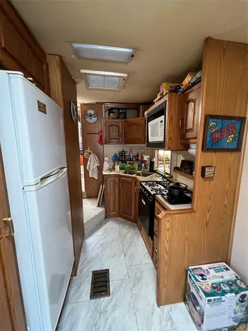 a kitchen with stainless steel appliances granite countertop a refrigerator a stove a sink and a microwave