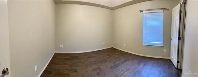 a view of a small space with wooden floor and a window