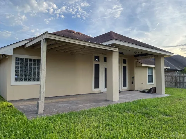 a view of a house with brick walls and a yard with plants