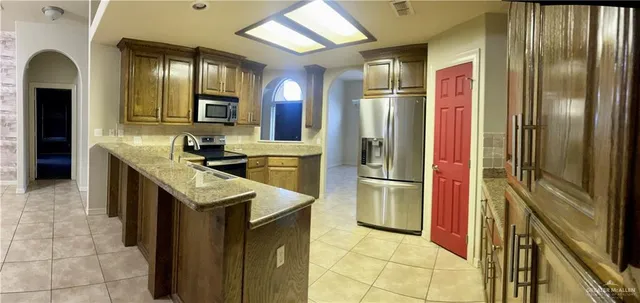 a kitchen with stainless steel appliances granite countertop a refrigerator and a sink