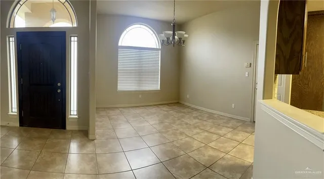 a view of an empty room with window and bathroom