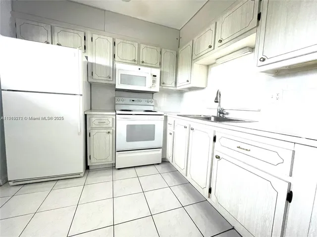 a kitchen with a stove a sink and a refrigerator