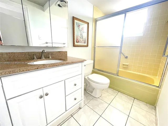 a bathroom with a granite countertop sink toilet a mirror and shower