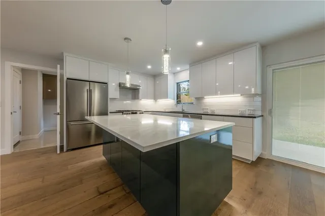 a kitchen with kitchen island a sink stainless steel appliances and counter space