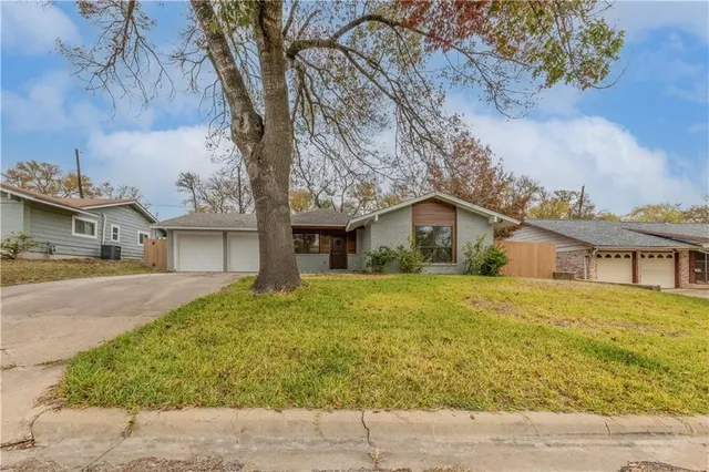 a front view of house with yard and trees around