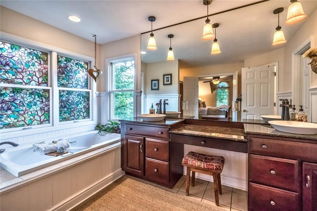 183 Davidson Road Mars, PA 16046 - Photo 16 of 25 Corner jet tub, dual vessel sink vanities with water fall fixtures and abdundant light! The walk-in closet is located off of the ensuite bathroom with hardwood floors in the walk-in closet.