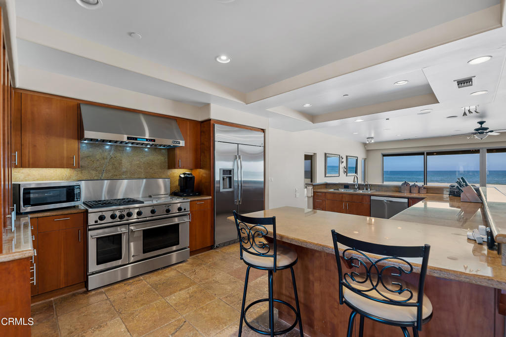 791 Mandalay Beach Road Oxnard, CA 93035 - Photo 19 of 46 a kitchen with stainless steel appliances a stove a sink cabinets and a dining table
