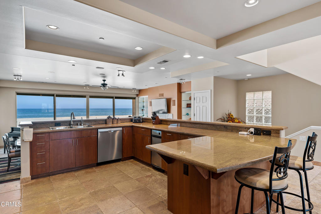 791 Mandalay Beach Road Oxnard, CA 93035 - Photo 21 of 46 a kitchen with stainless steel appliances granite countertop a table chairs sink and cabinets
