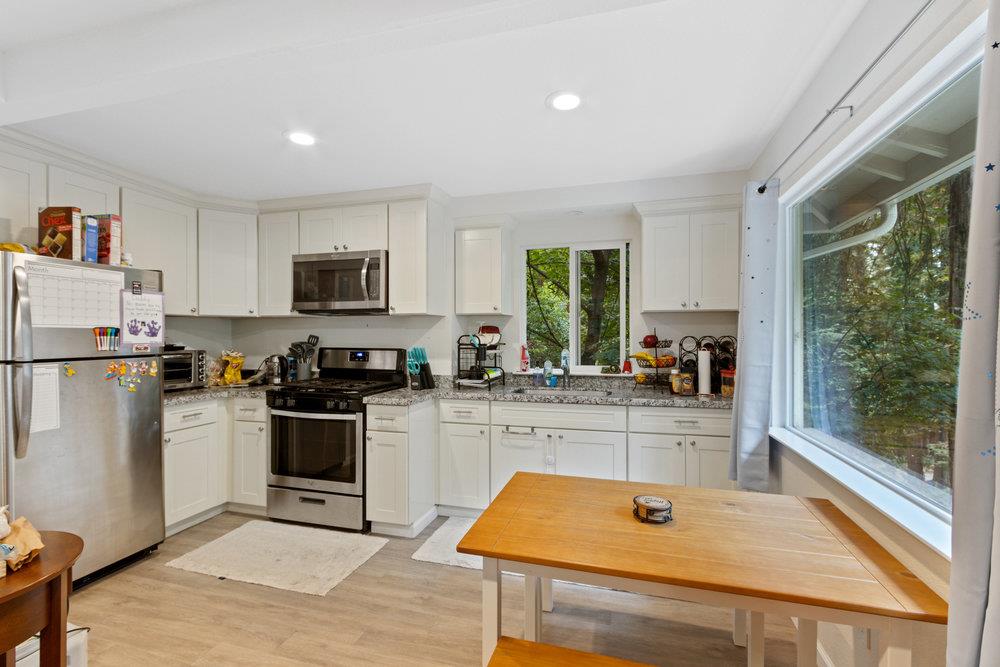 35 Park Way Mount Hermon, CA 95041 - Photo 26 of 46 a kitchen with stainless steel appliances granite countertop a refrigerator a stove top oven a sink dishwasher and white cabinets with wooden floor