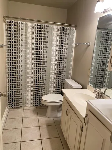 a view of an empty room and chandelier fan