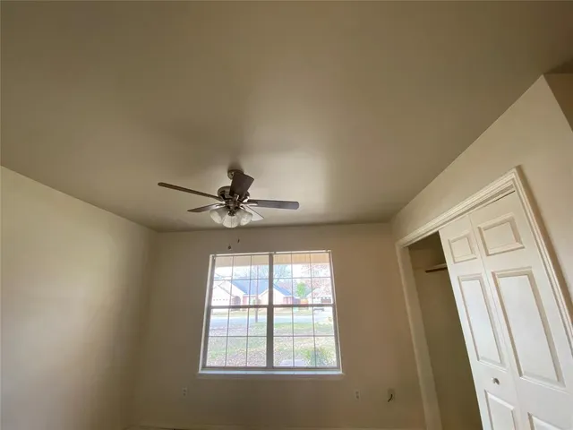 a view of a livingroom with a ceiling fan and window