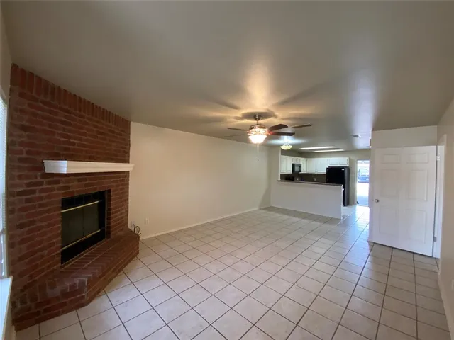 a view of empty room with fireplace and fan