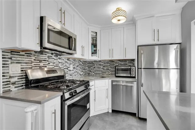 a kitchen with cabinets stainless steel appliances and wooden floor