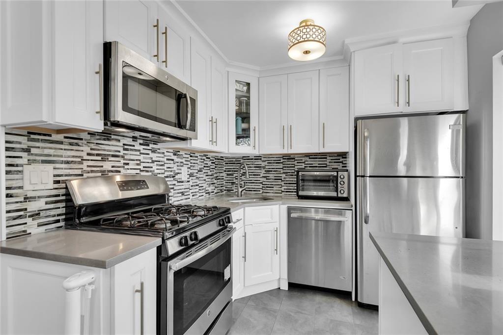 1265 Shore Parkway, Unit 2C Brooklyn, NY 11214 - Photo 4 of 11 a kitchen with cabinets stainless steel appliances and wooden floor