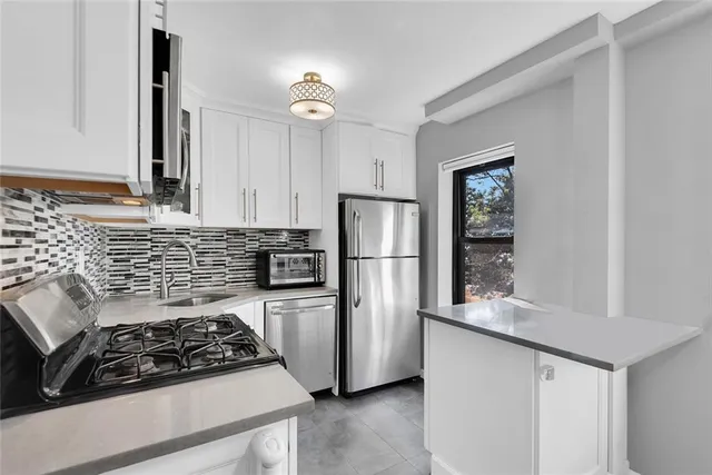 a kitchen with white cabinets and appliances