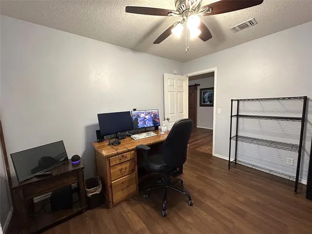a view of a workspace with furniture and a ceiling fan