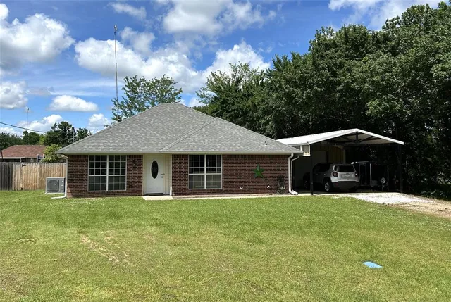 a front view of house with yard and trees