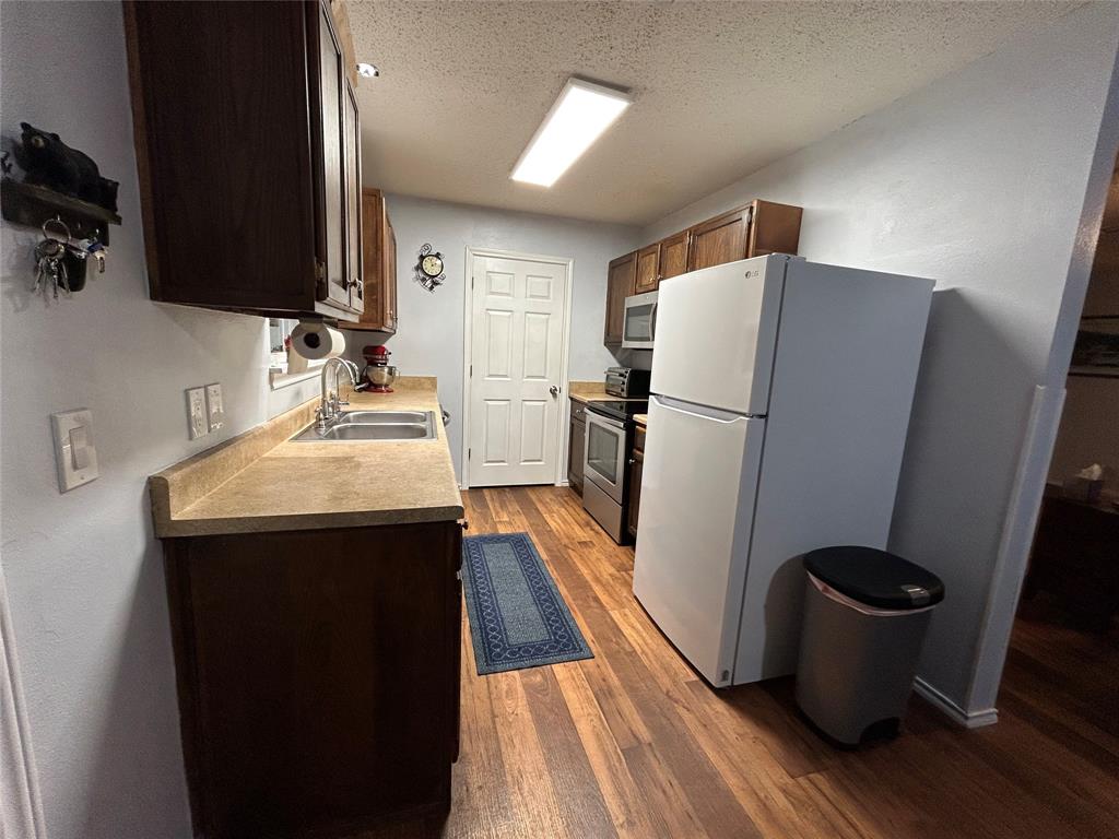 1974 County Road Powderly, TX 75473 - Photo 10 of 33 a kitchen with a refrigerator and a sink