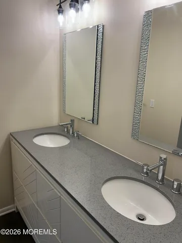 a bathroom with a sink vanity granite and a mirror
