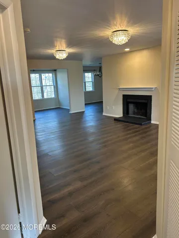 a view of an empty room with a fireplace and a window