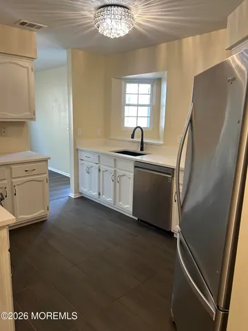 a kitchen with stainless steel appliances a refrigerator a sink a stove and cabinets