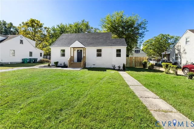 a front view of a house with a yard and trees