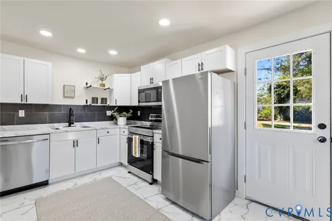 a kitchen with stainless steel appliances a refrigerator sink and microwave