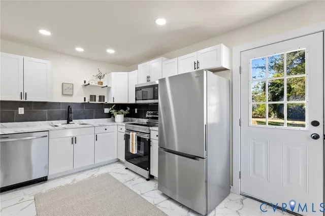 a kitchen with stainless steel appliances a refrigerator sink and microwave