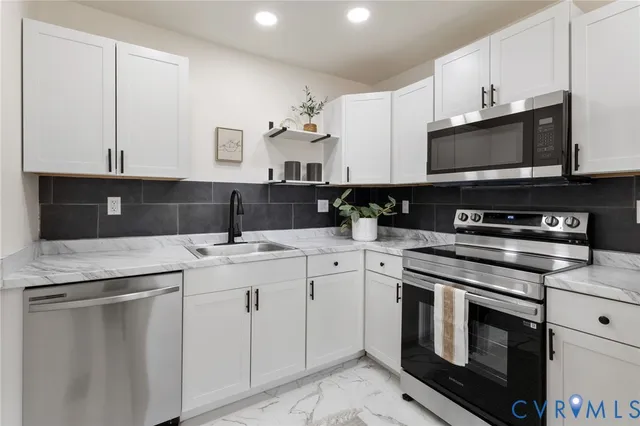a kitchen with stainless steel appliances granite countertop a sink and a stove