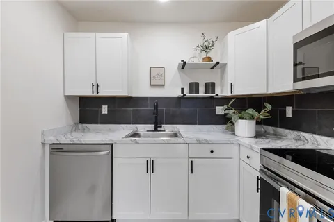 a kitchen with stainless steel appliances granite countertop a sink and cabinets