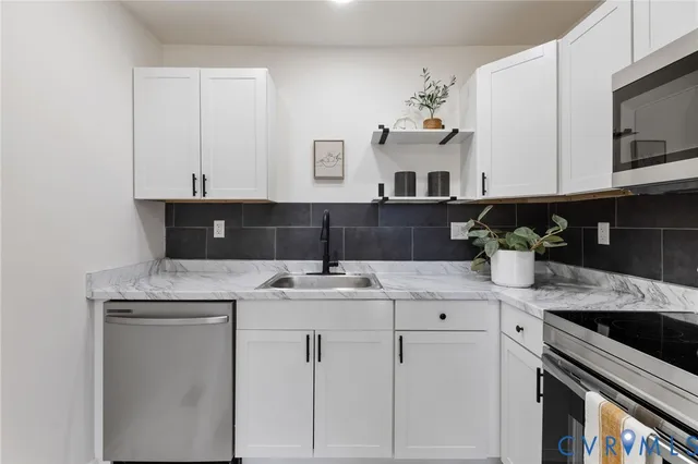 a kitchen with stainless steel appliances granite countertop a sink and cabinets