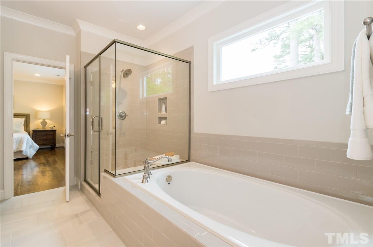 3201 Plantation Road Raleigh, NC 27609 - Photo 16 of 25 a bathroom with a tub shower and a sink