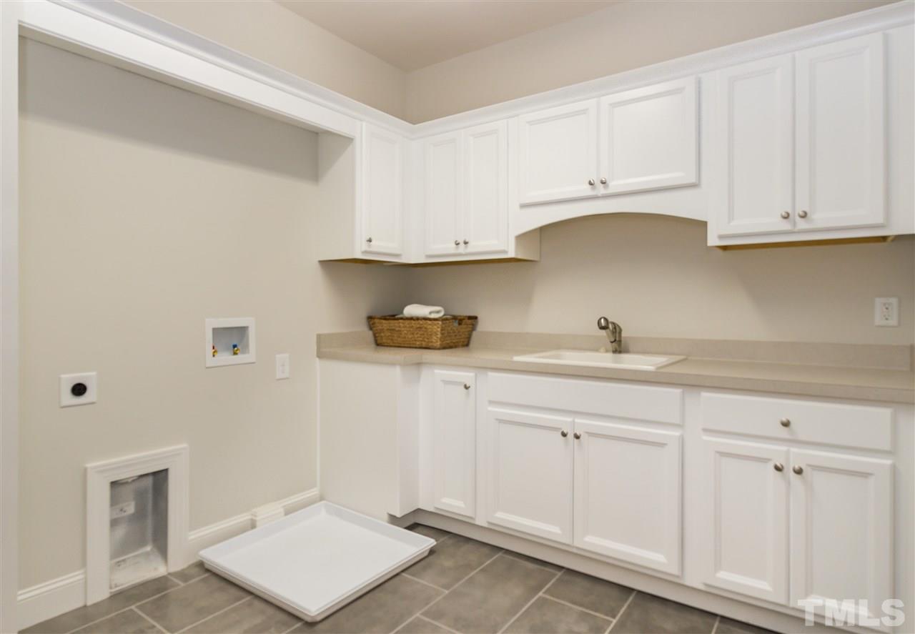 3201 Plantation Road Raleigh, NC 27609 - Photo 20 of 25 a kitchen with white cabinets and sink