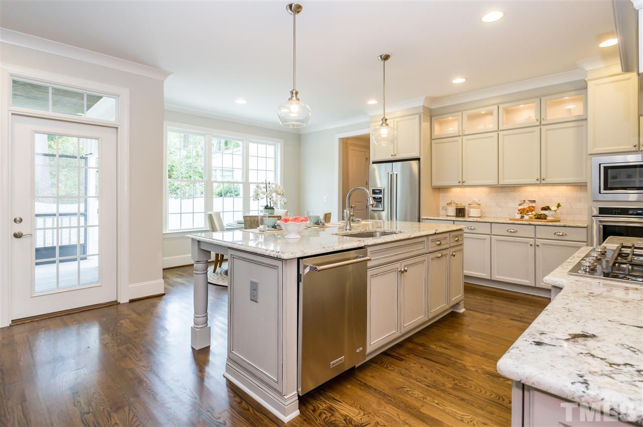 3201 Plantation Road Raleigh, NC 27609 - Photo 8 of 25 a kitchen with a sink stove cabinets and wooden floor