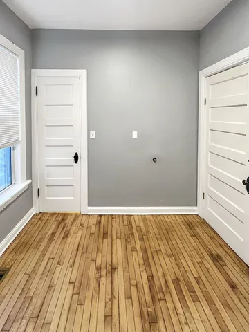 a view of a room with wooden floor and window